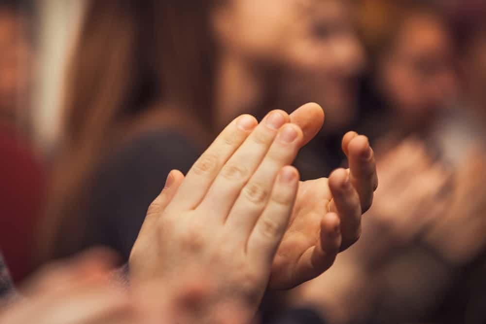 A group of people clapping their hands at the KOA Convention.
