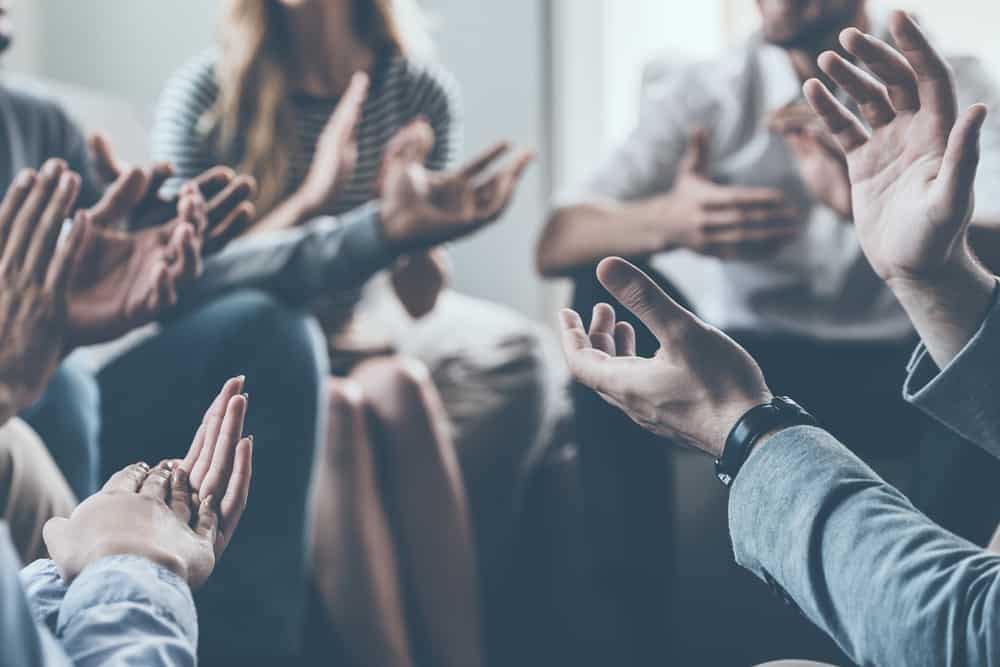 A group of people from Canada clapping their hands together.