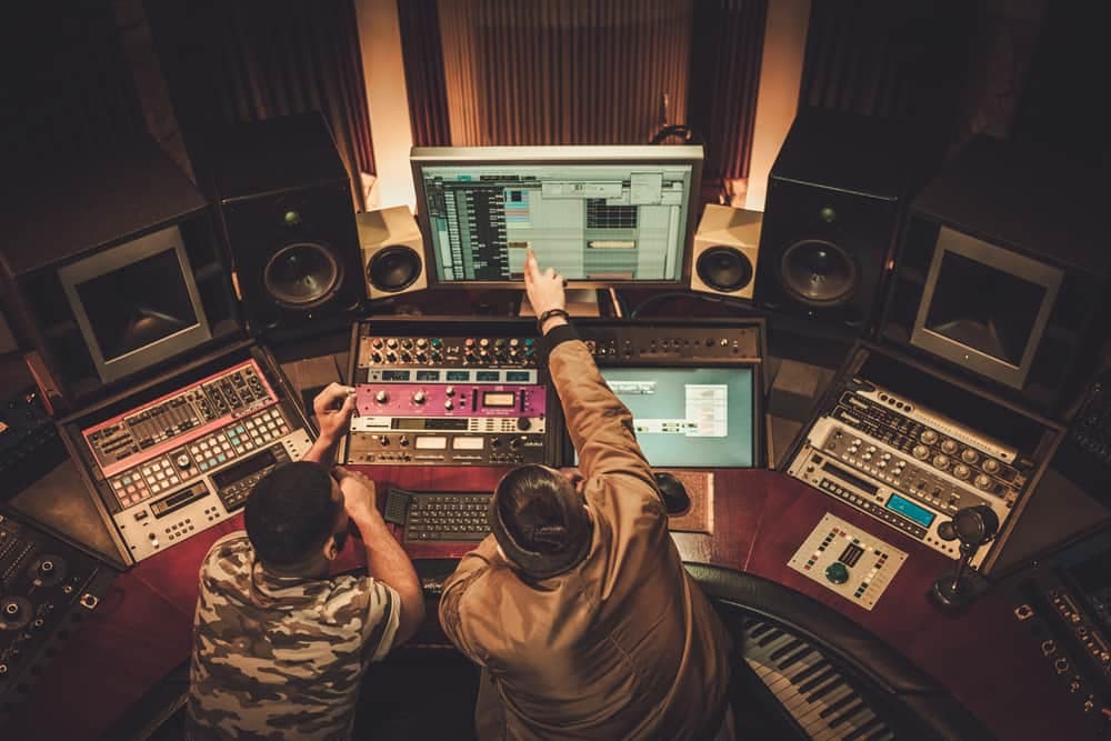 Two men working with a Resonado sound system in a recording studio.