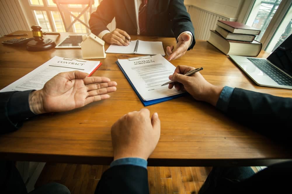 Two businessmen signing a contract at a table in Canada's Parliament.
