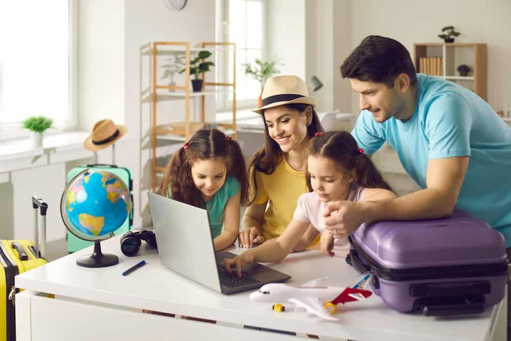 A family is using a laptop to access RoverPass and Vrbo Integration while sitting at a table.