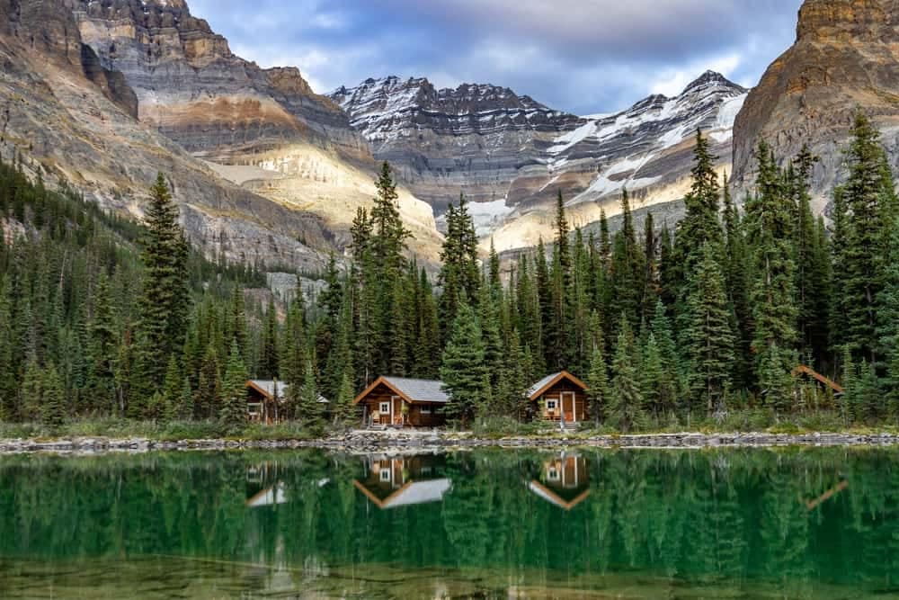 Cabins on the shore of a lake in British Columbia, surrounded by the majestic mountains.