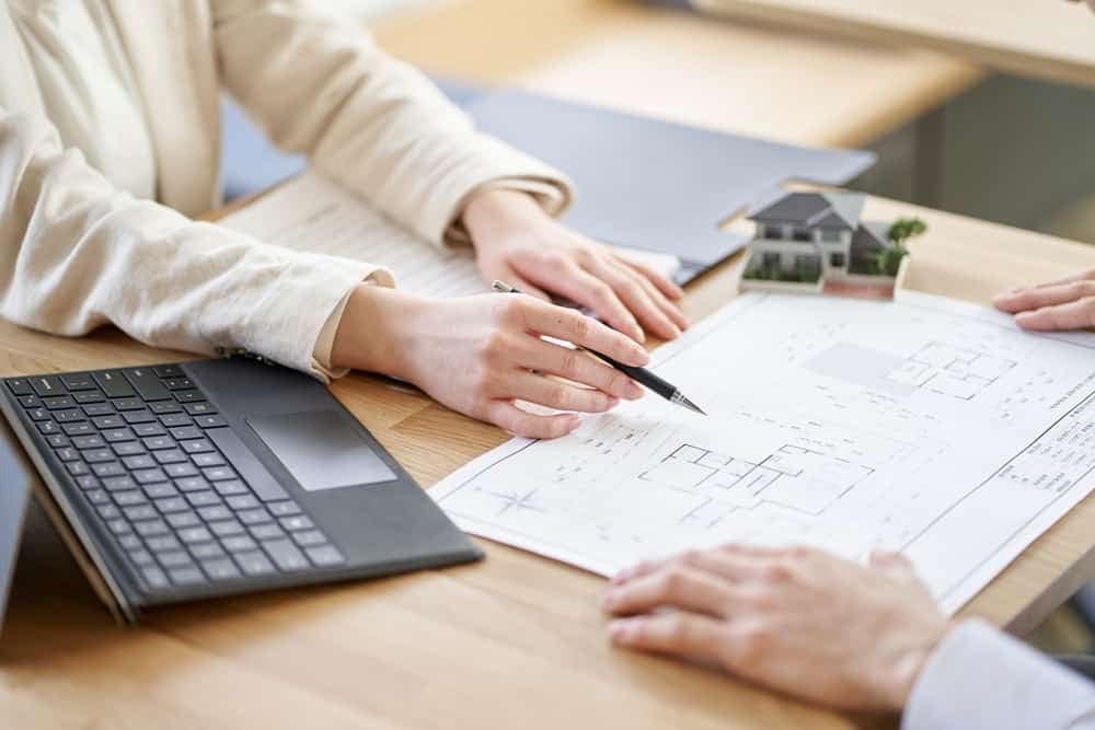 Two people working on a blueprint for cabins and RV pads at a desk.