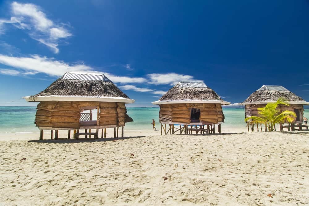Three beachfront wooden huts on the Pacific Coast.