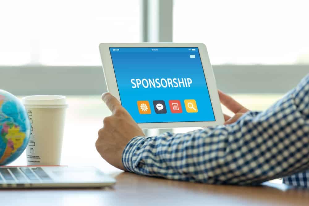 A man using a tablet to explore Sponsorship Opportunities at the Canadian Outdoor Hospitality Conference & Expo, organized by CCRCV.