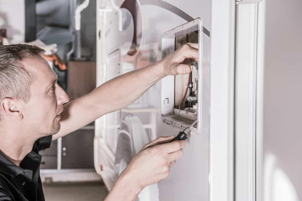 An RVTI-trained technician empowers campground owners by efficiently fixing a light in an RV, upholding the gold standard of technician training.