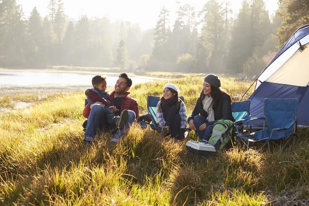 A group of Visitors sitting in front of a tent at one of the California State Parks.