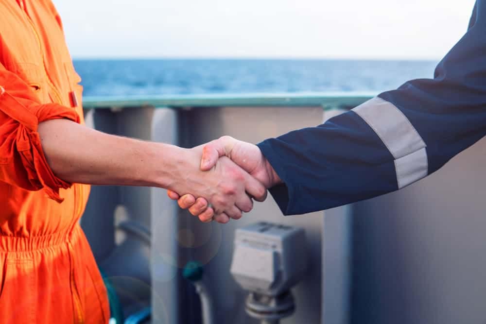 Two men shaking hands on the deck of a ship in Maryland.