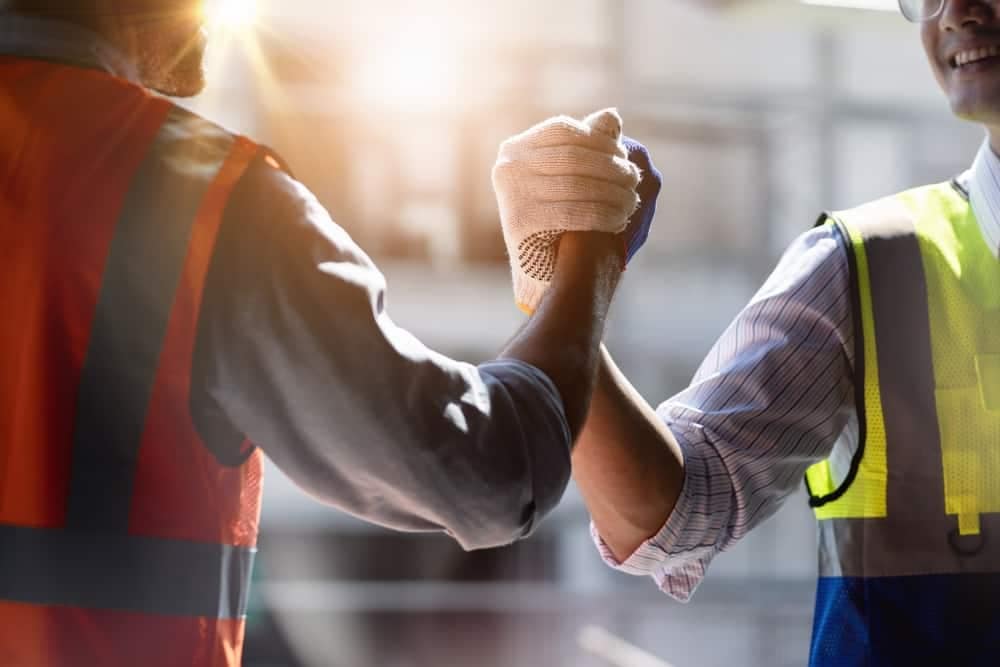 Two construction workers shaking hands during RV Technician Classes at April 2023's RV Technical Institute.