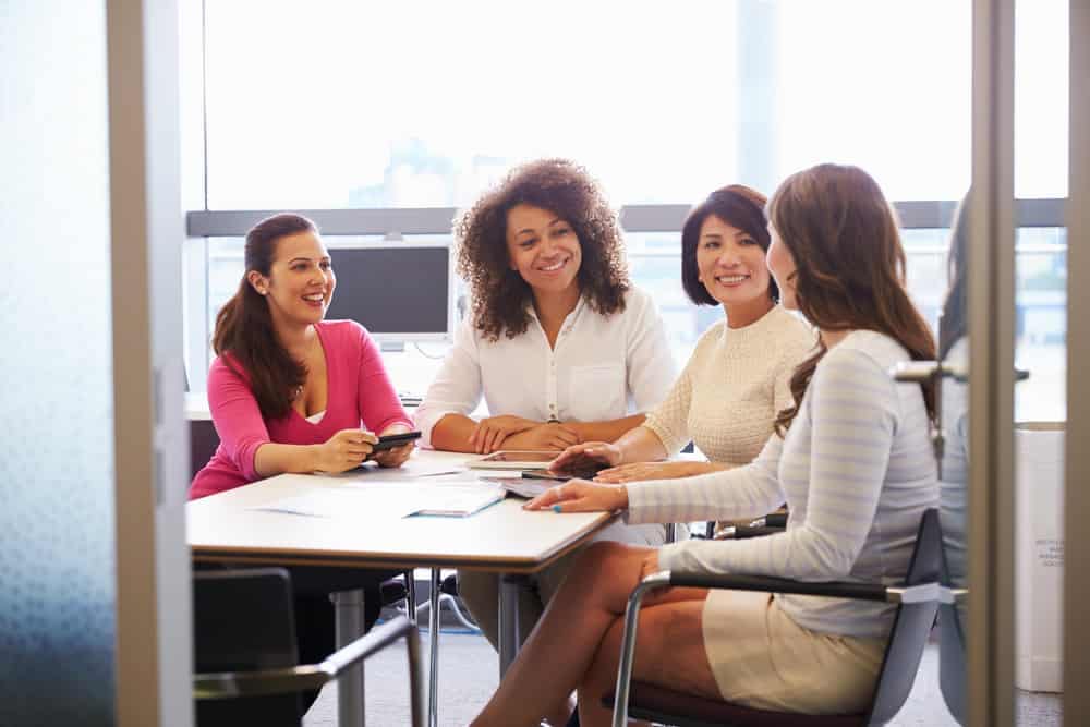 A group of Unstoppable Women sitting around a table in an office.