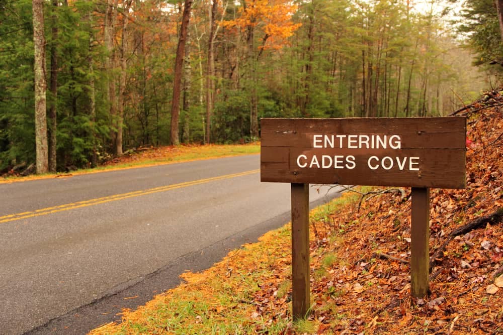 A sign that says entering Cades Cove Area on the side of a road.
