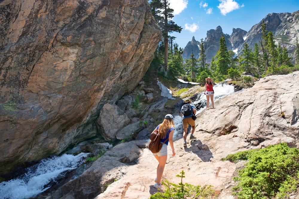 A group of hikers hiking up a rocky trail near Rocky Mountain National Park.