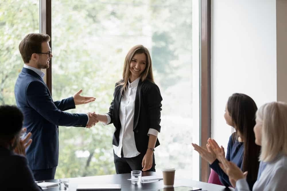 A group of business people from the RV Industry Association shaking hands at a meeting to celebrate new members and discuss innovation.