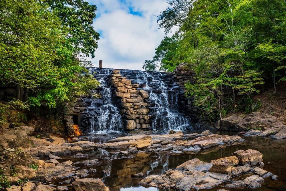 A glamping experience amidst the ultimate comfort of a wooded area, featuring a picturesque waterfall. Located in Alabama State Parks.