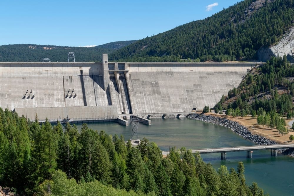 A large dam on the Kootenai River with a lake in the background.