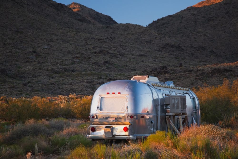 A silver Airstream, recipient of the Five Rivet Award, parked in the desert.