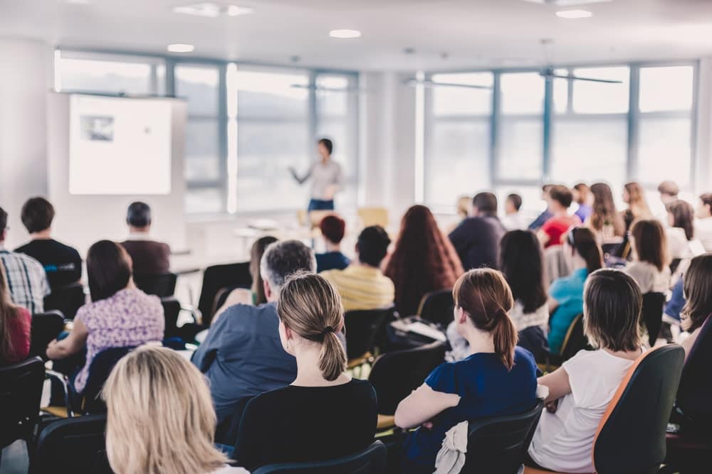 A group of people in a conference room watching a presentation during the Global Innovation Summer Program.