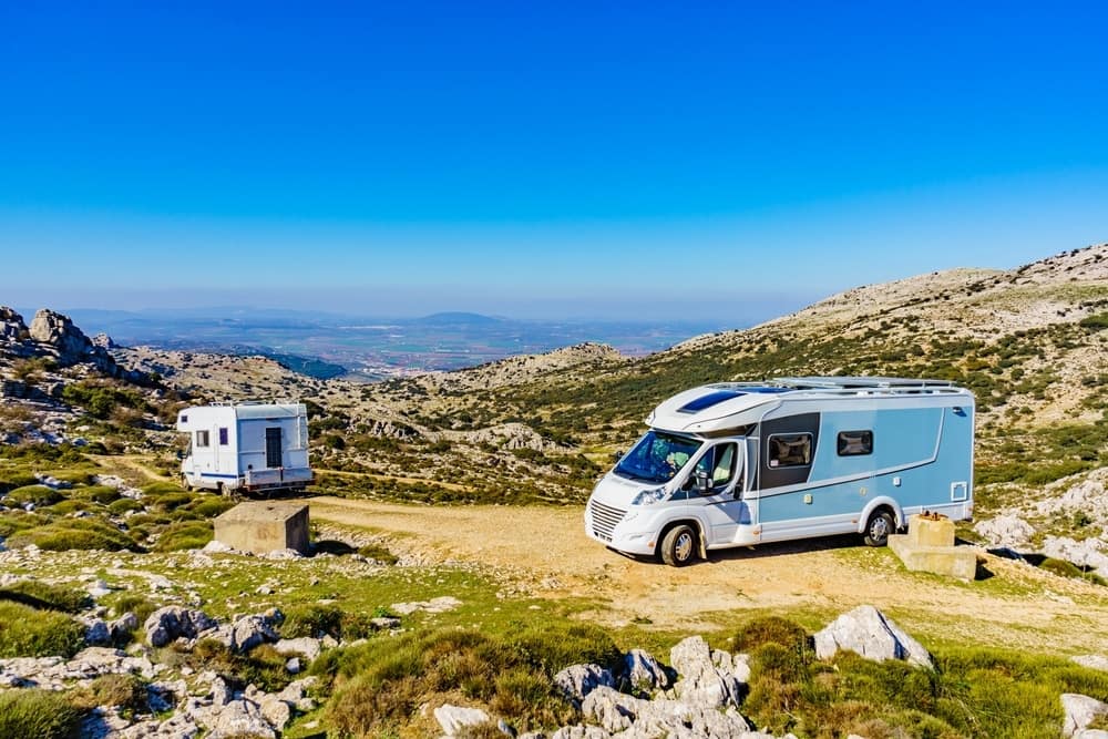 Two rvs parked on the side of a mountain in the Spanish Caravanning Sector.