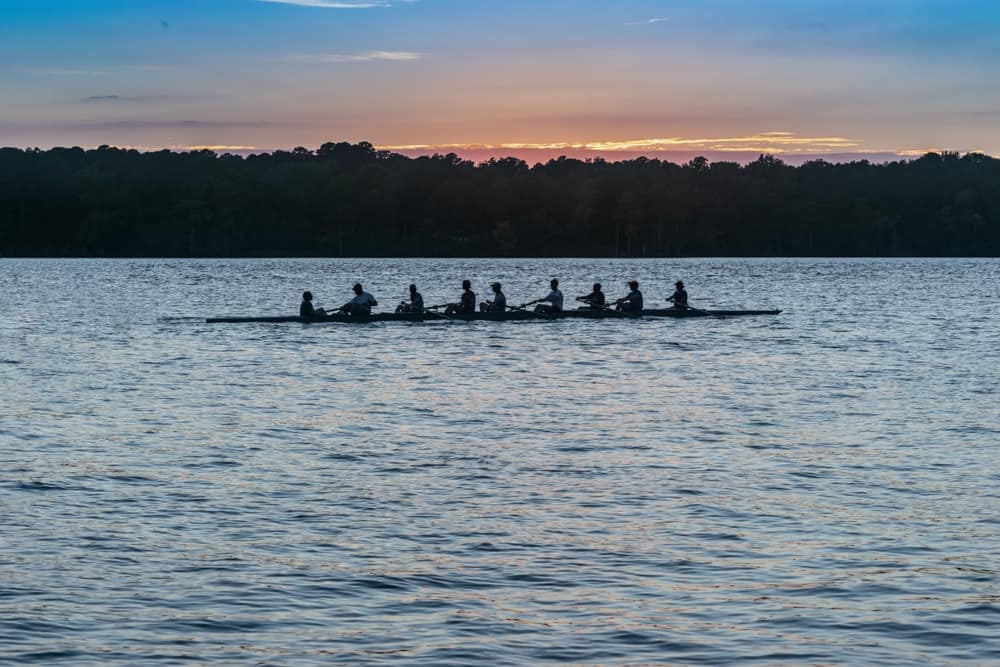 A group of rowers on a lake at sunset, enjoying the tranquil Timberline scenery.