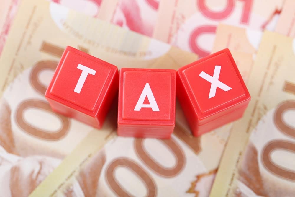 A red block with the word tax on top of a stack of Canadian dollars, aimed at private campground owners in Canada who can benefit from the small business deduction.
