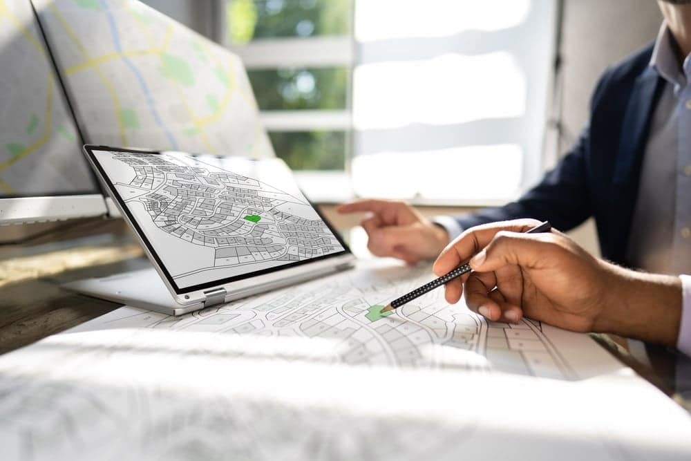 A man in a suit is looking at a map on his laptop while camping on 30-Acre Youngstown Road.