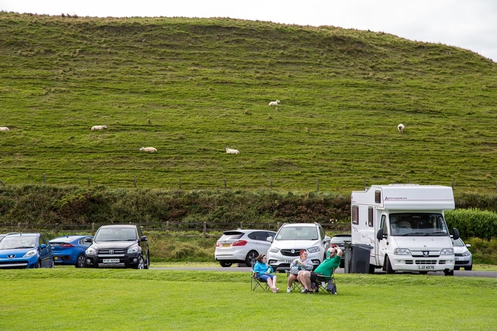 A caravanning experience on a grassy hill in Northern Ireland, with sheep grazing in the background.