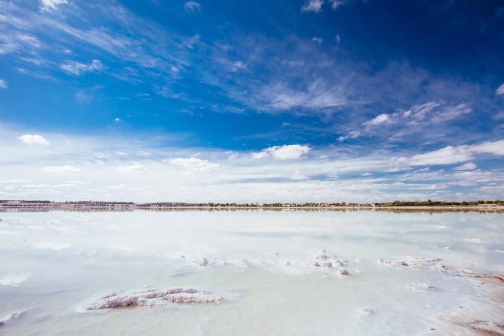 A serene body of water with a blue sky and clouds.