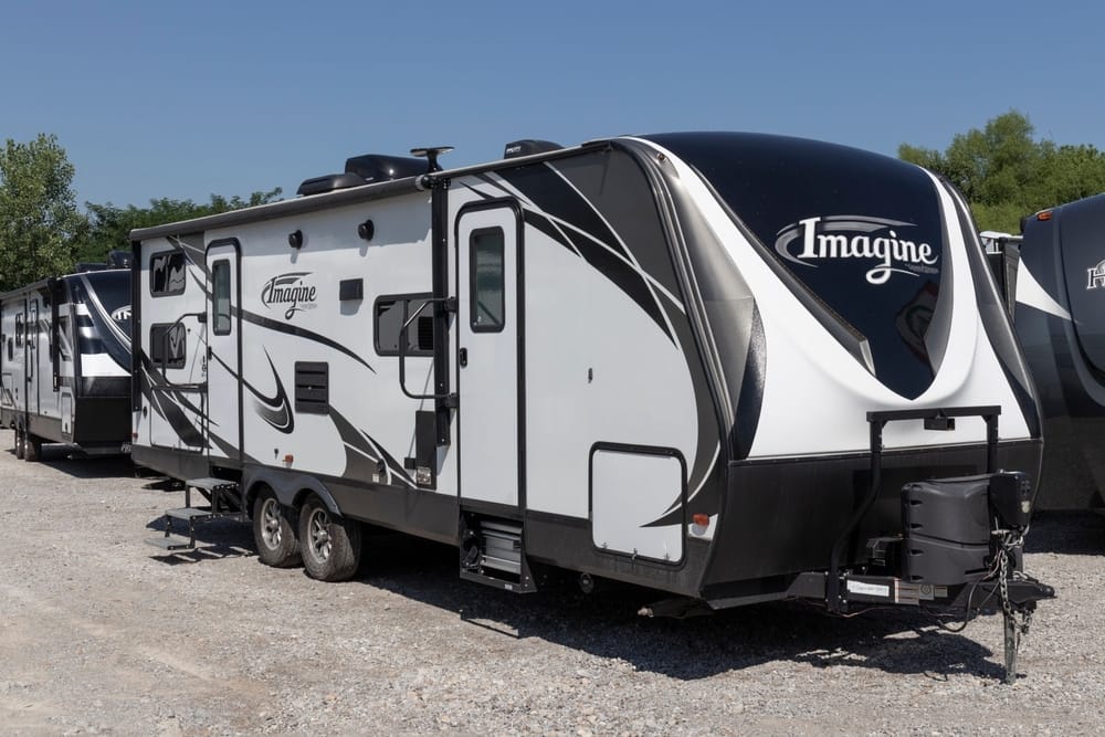 A historic milestone achieved with the production of the 250,000th Grand Design RV, showcased by a group of black and white rvs parked in a lot.