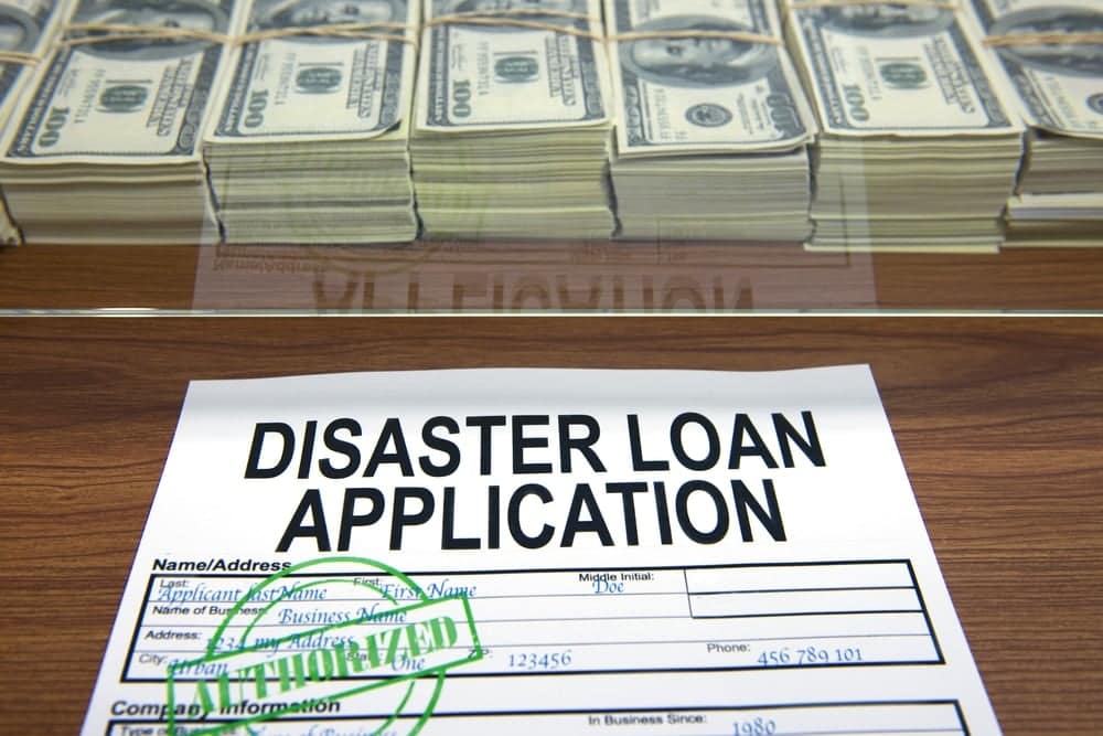 Virginia disaster loan application on top of piles of money.
