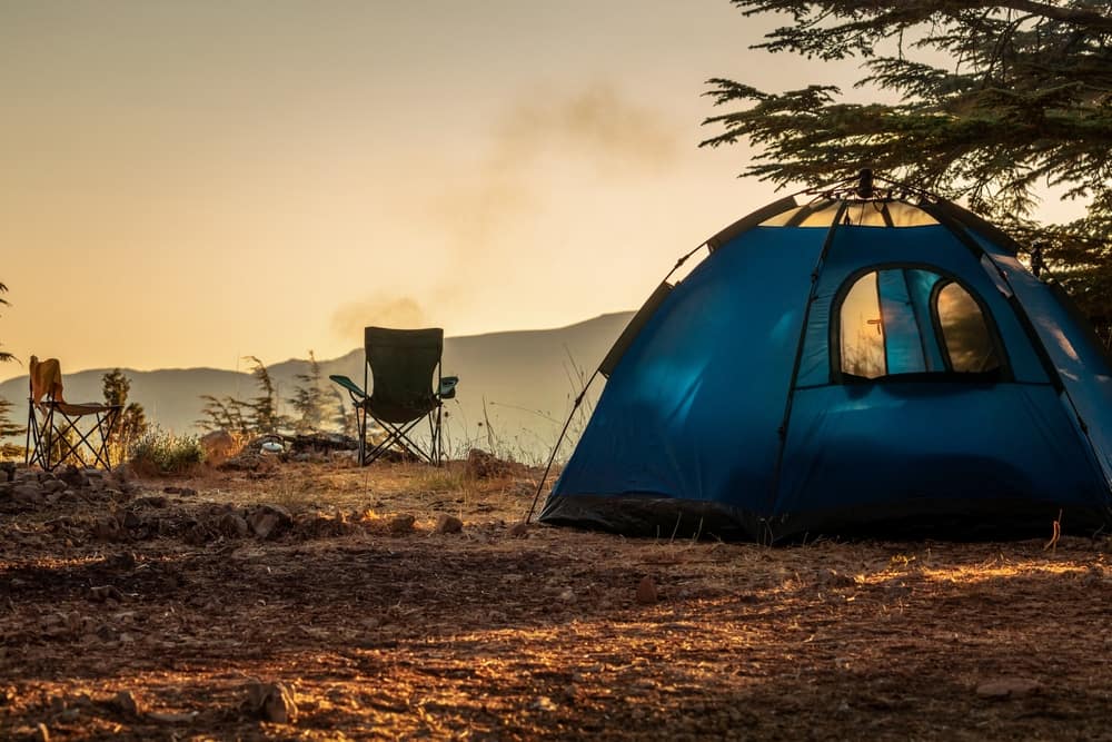 A tent is set up in the middle of a wooded area perfect for fall camping.