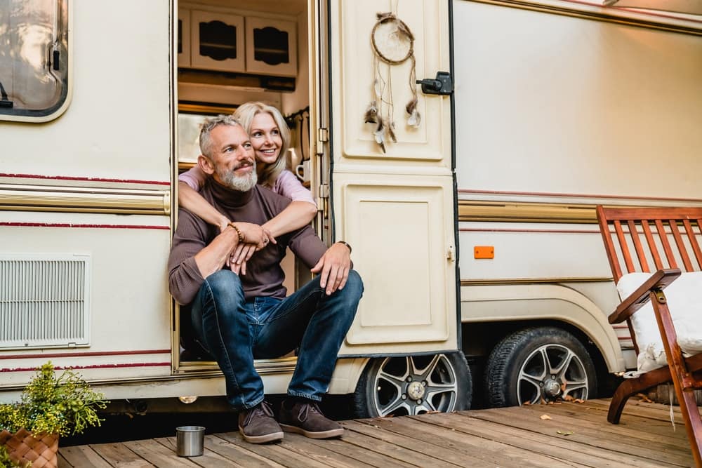An older couple, known as "Snowbirds," sitting on the porch of their RV.