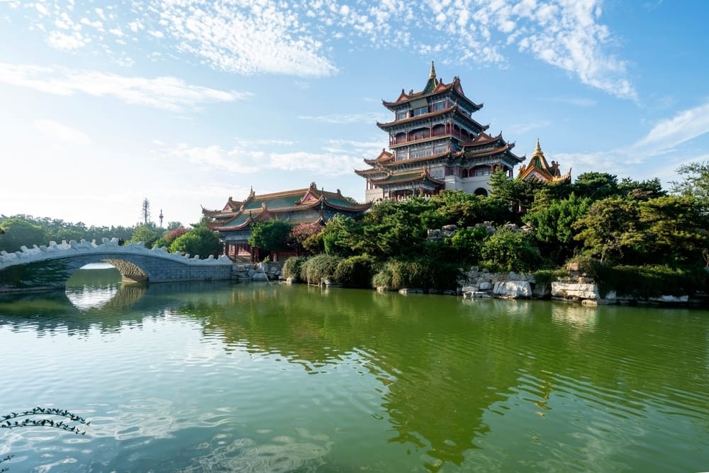 A model of a Chinese pagoda in Guiyang, a tourism hotspot, situated on a beautiful lake with a charming bridge.