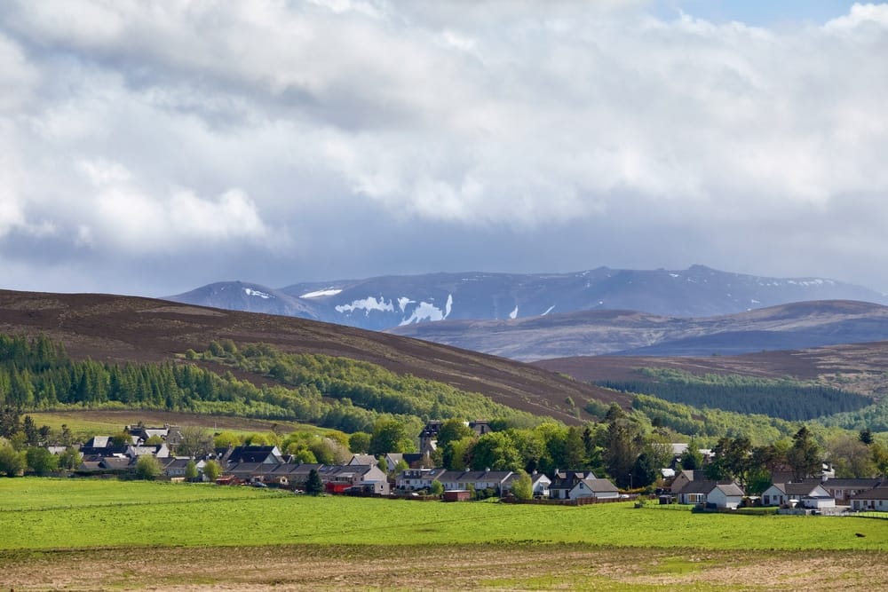 A Tomintoul village in Scotland nestled in the breathtaking mountains with a picturesque campsite, offering an enchanting revival of nature's beauty.