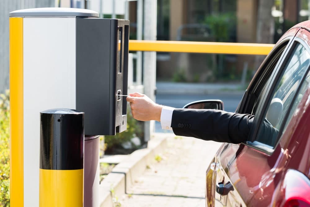 A Non-Resident man in a suit is pointing at a parking meter in Ontario City.