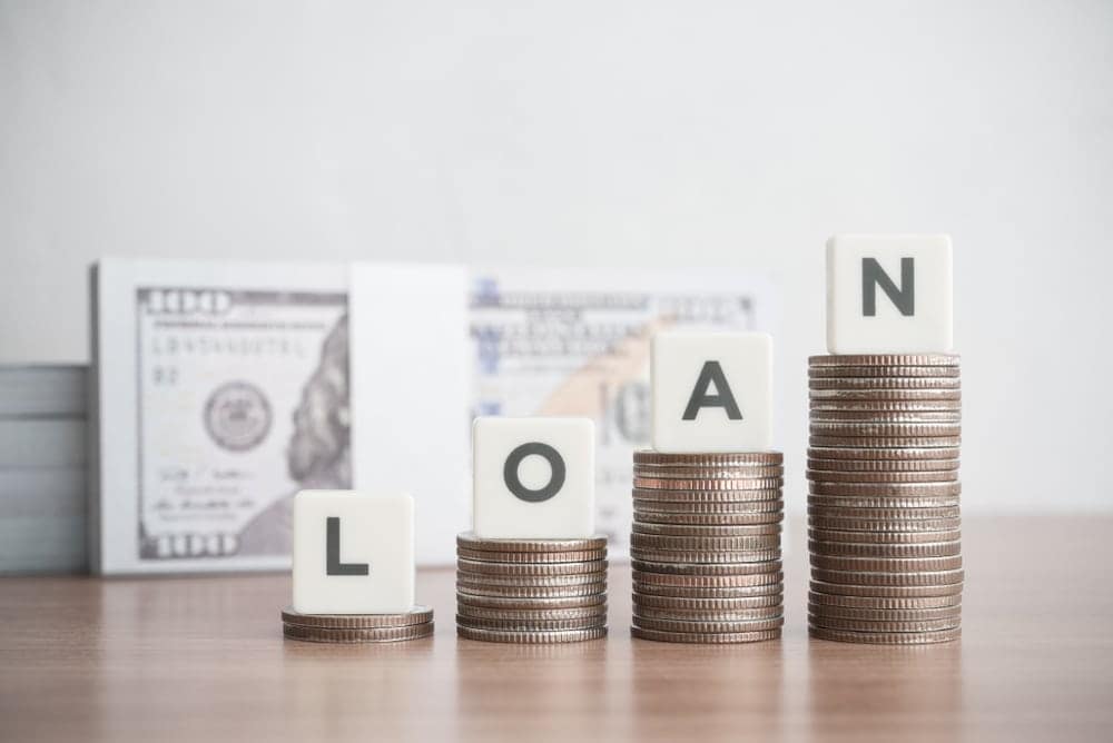 Stacks of coins with the word loan on top of them.