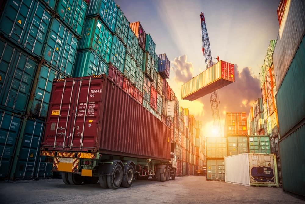 A truck is navigating through a warehouse filled with containers, unaffected by the global inflation and consumer prices.
