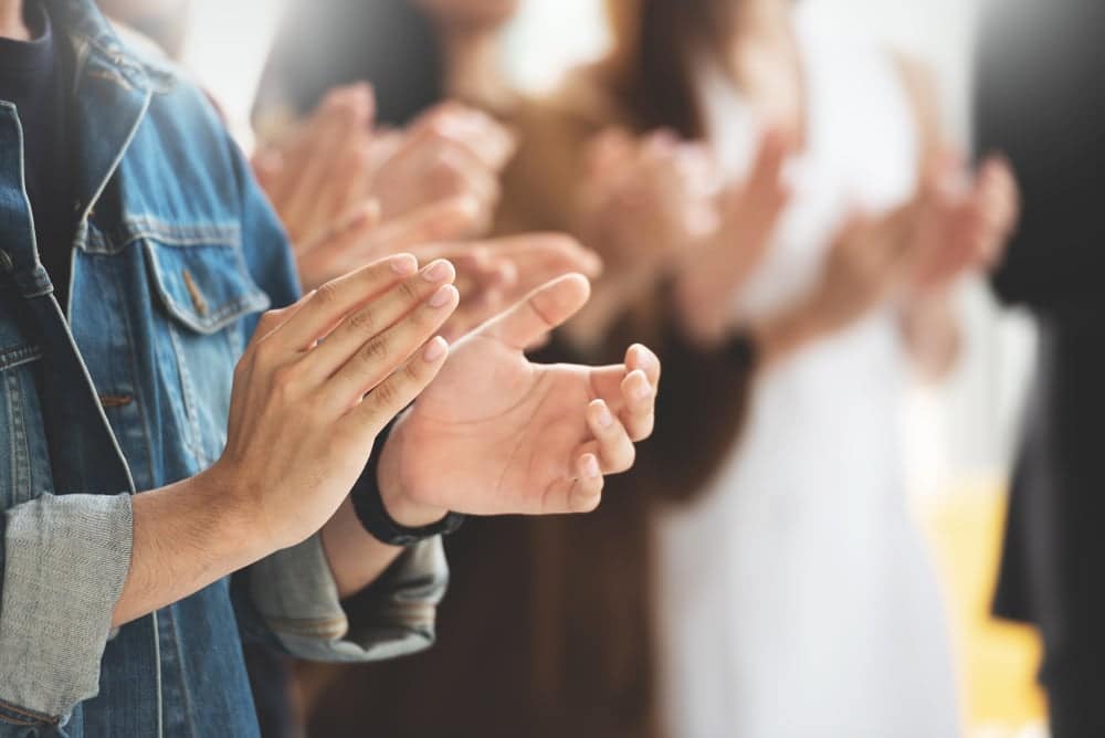 SuperSprings International team members enthusiastically clapping their hands together, embracing the new leadership structure.