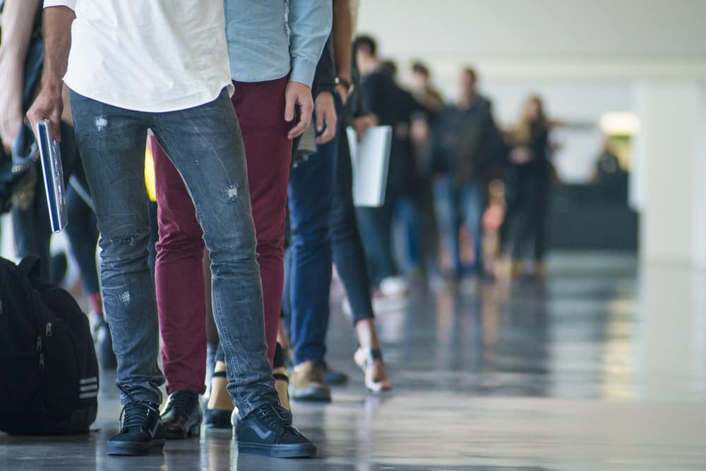 A group of people walking down a hallway with luggage in the US.