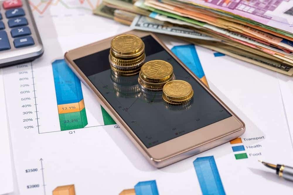 A Cavco smartphone with coins sitting on top of a pile of papers in the third quarter of fiscal 2022.
