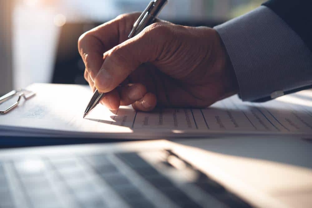 A person signing Operating Guidelines with a pen at an RV Park.