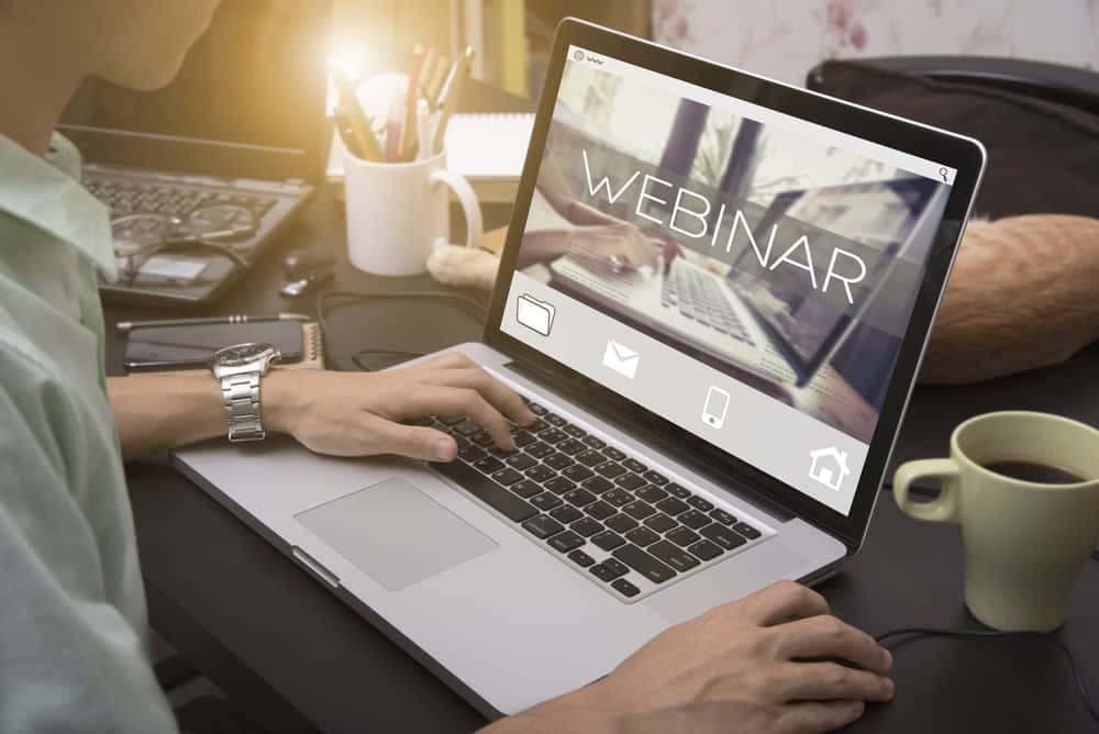 A man participating in a webinar while using his laptop.
