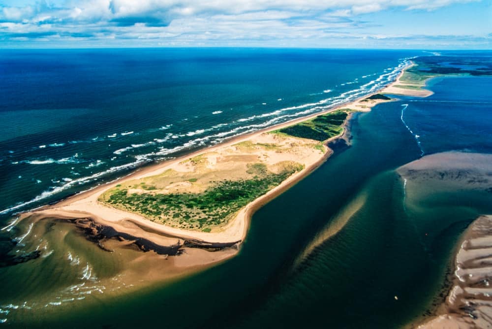 An aerial view of a sand dune and ocean in Prince Edward Island National Park.