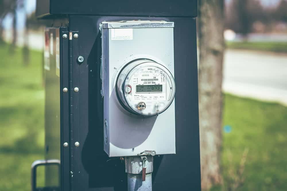 An energy meter is sitting on the side of the road, monitoring electrical usage.