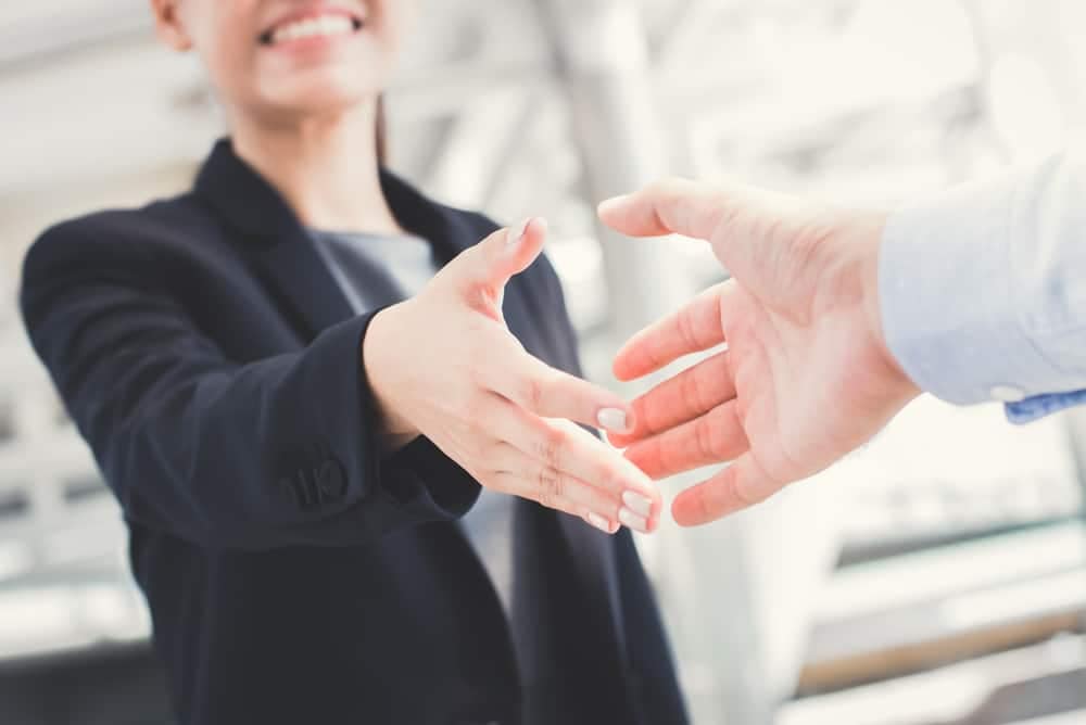 Two business people shaking hands in an office at Park Holidays UK.