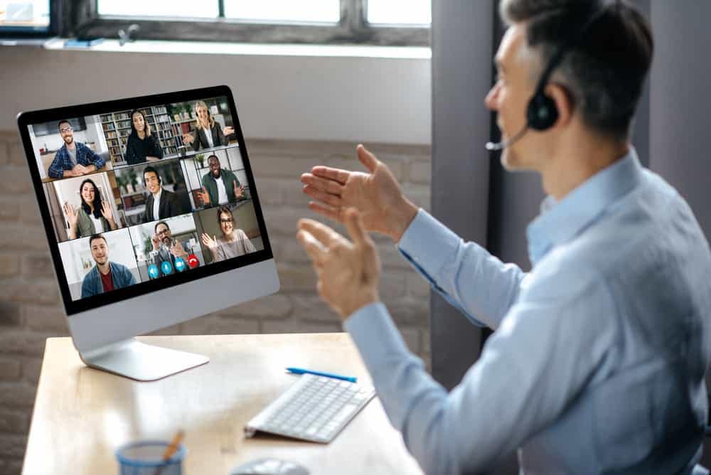 At the 2023 Canadian Outdoor Hospitality Conference, a man in a headset is delivering a presentation to a group of people on a computer at Signature Park.