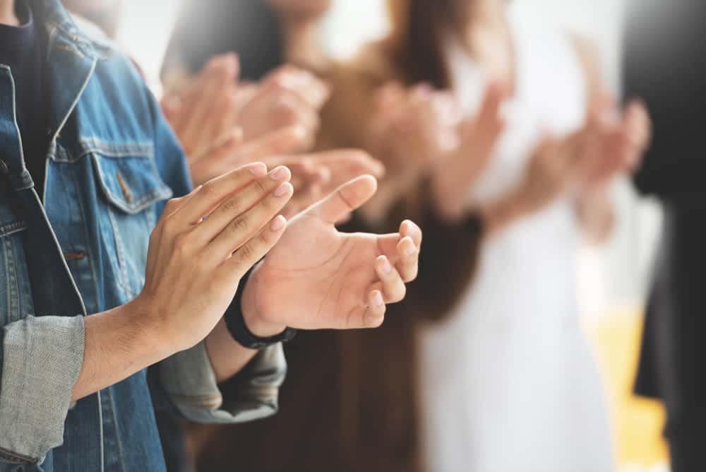 A group of people clapping their hands together at the Outstanding Member Awards ceremony in the RV Park and Campground Industry.