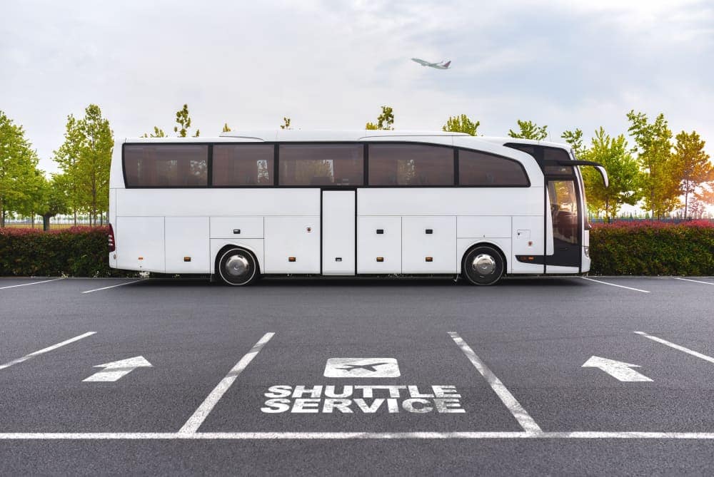A white Hiker Shuttle bus is parked in a parking lot at Rocky Mountain National Park.