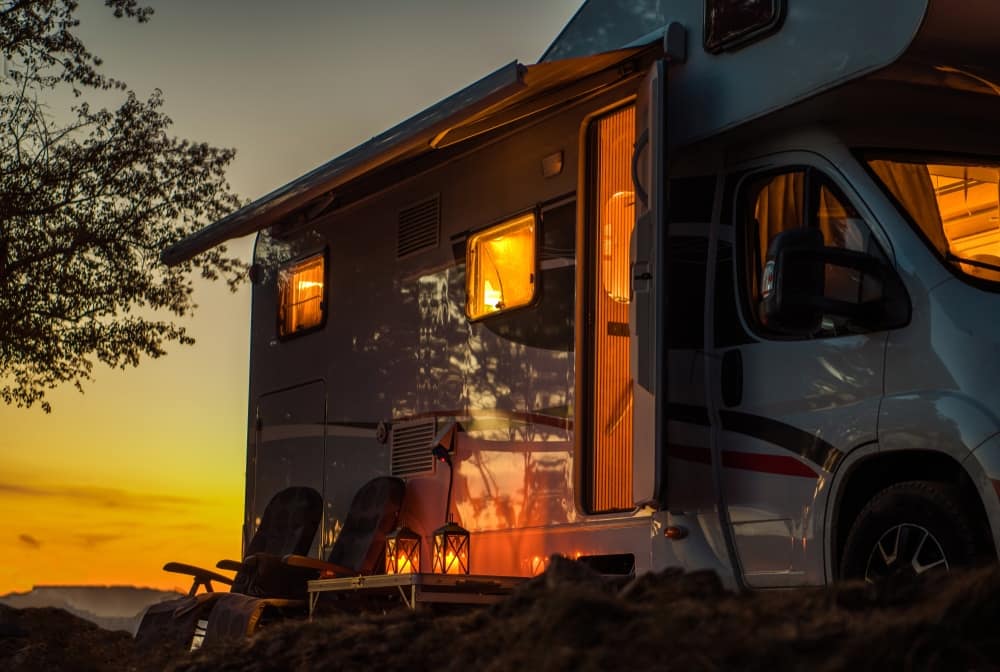 A white RV belonging to Barefoot RV Park LLC is parked in a field at sunset, as part of a Variance Request presented to the Humble City Council.