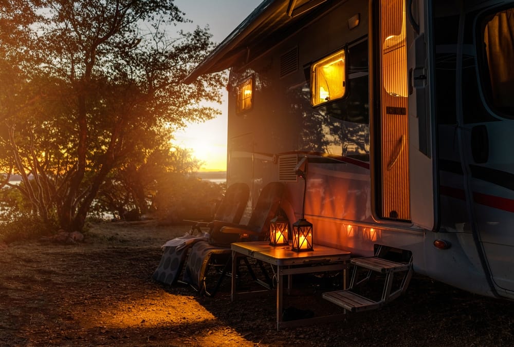 An RV parked in the woods at sunset, capturing the enchanting atmosphere of October 31.