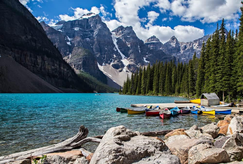 Canoes on the shore of a lake with mountains in Banff National Park.